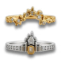 Two rings displayed on a clean white reflective surface: a gold ring with a castle-like top and small clear stones, and a two-tone silver and gold ring with a castle motif and a central rectangular clear stone.